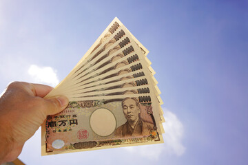 青空にかざされた１０万円