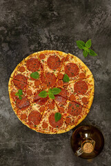 Obraz na płótnie Canvas Tasty pepperoni pizza and fresh basil on dark background.