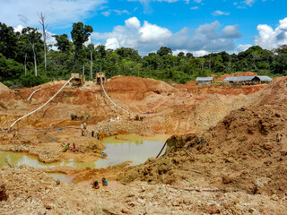 Gold mining place in Guyana, local indigenous people clear workspace from stones and check it for...