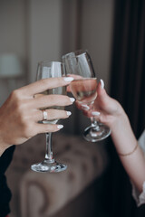 two women's hands with champagne glasses in their hands