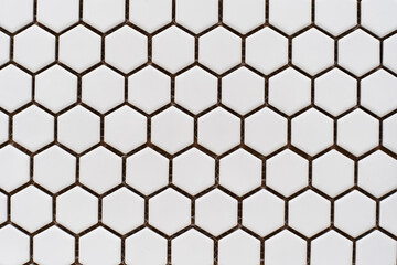 White ceramic tiles in the form of honeycombs. Sample wall cladding in a specialist store. Flat...
