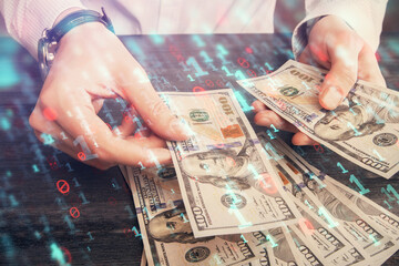 Double exposure of technology drawing hologram and us dollars bills and man hands. Data concept