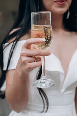 the bride holds a glass of champagne in her hand