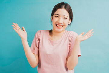 Portrait of cheerful girl raising her hand on green background