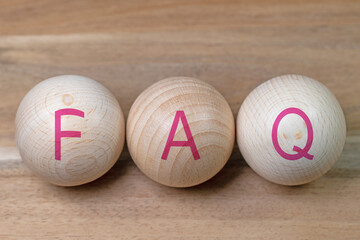 Drei Holzkugeln mit dem Aufdruck FAQ