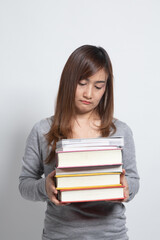 Unhappy young Asian woman studying  with may books.