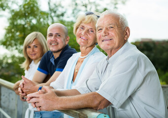 .elderly parents with older children relax in the garden