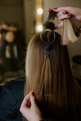 In the beauty salon, woman hairdresser cut selects a hair sample for the wig.