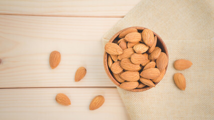 Almonds raw peeled in brown wooden bowl on wooden table background.Healthy food Concept