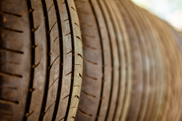 Old car tires stand on a metal rack