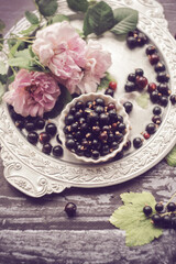 Damask rose, currants and rosehip flowers on an old vintage tray, garden roses, garden still life