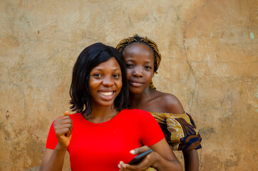 happy sisters having fun with mobile smart phone outdoor - new normal tech concept with sisters together