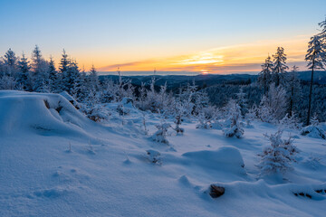 Frosty winter sunrise in mountain foresty with snow covered fir trees. Great outdoor scene, Happy New Year celebration concept. Artistic style post processed photo. Orton Effect.
