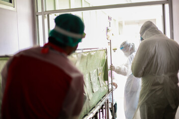 Medical team wear PPE suit moving coronavirus infected patient to treatment in hospital...