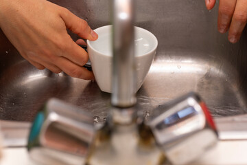 Llenando una taza de agua en el grifo.