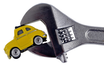 Concept de mécanique avec une voiture tenue par une clé à molettes en gros plan sur fond blanc