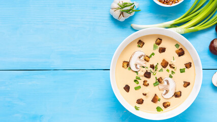 Homemade chestnut soup on a blue wooden background with various seasonings. Top view, Copy space.