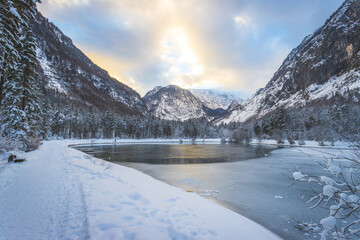 Winter landscape with frosty lake, snowy trees and mountains. Buntautal and Bluntausee. © Patrick Daxenbichler