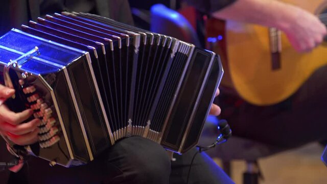 A Bandoneon accordion player is practicing for a tango music show, philharmonic orchestra