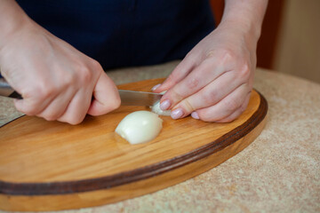 Young woman cuts onion. Cooking Ukrainian borscht step by step