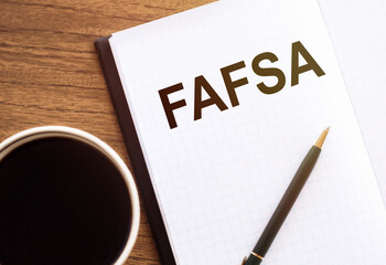 FAFSA text on notepad on wooden desk.