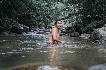 A male traveler in the rain forest pool stream or waterfall.Healthy and active lifestyle.Camping and hiking.