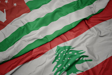 Obraz premium waving colorful flag of lebanon and national flag of abkhazia.