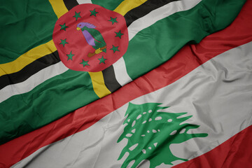 waving colorful flag of lebanon and national flag of dominica.