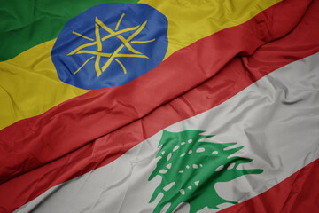 waving colorful flag of lebanon and national flag of ethiopia .