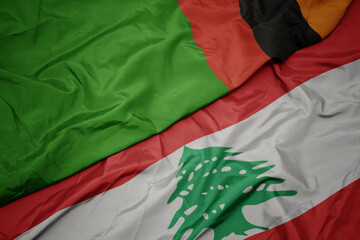 waving colorful flag of lebanon and national flag of zambia.