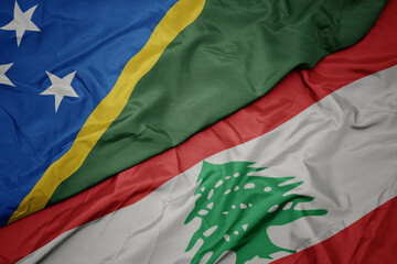 waving colorful flag of lebanon and national flag of Solomon Islands .
