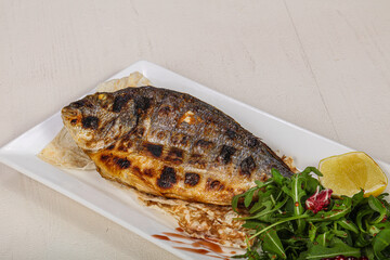 Grilled dorada fish served lemon