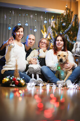 Family at christmas time. A woman,grandmother and daughter siting together near christmas tree with lighting and decoration in flat