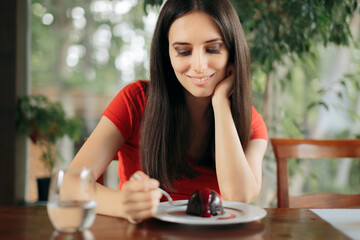 Happy Woman Eating Chocolate Cookie in a Restaurant