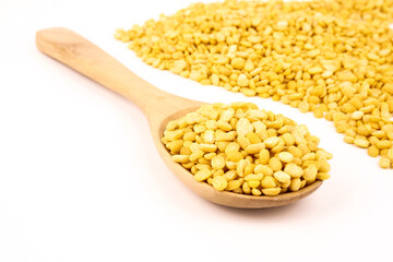 peeled split mung bean in wooden scoop isolated on white background.Ingredients for cooking Healthy and Natural Food concept