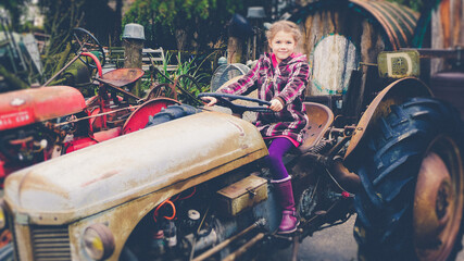 Fototapeta na wymiar Mädchen auf Traktor nostalgie