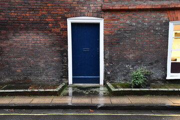 Blue door in the old brick wall in Winchester, England, Great Britain