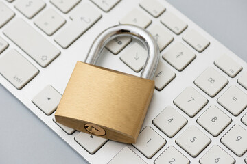 Locked Golden Padlock on the metallic keyboard.