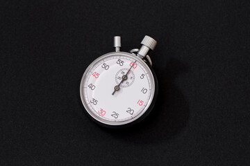 Analogue metal stopwatch on the black background.