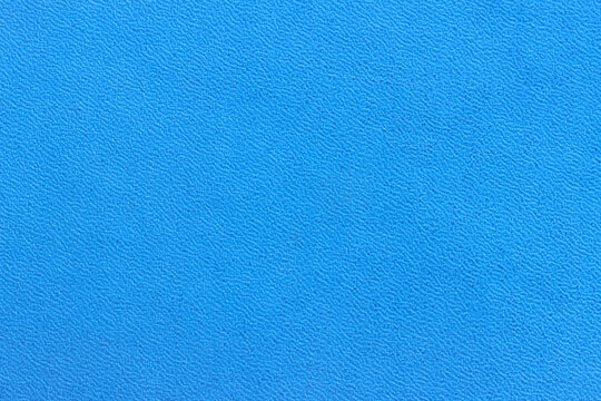 The surface of the blue old worn dermatin with a small pattern.