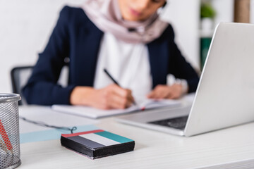 selective focus of digital translator with uae flag emblem near interpreter working on blurred...