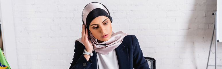 arabian translator in headset over hijab working in office, banner