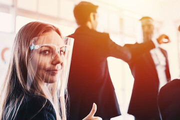 Meeting during pandemic with face, mask. Happy woman portrait with team handshake in background. 