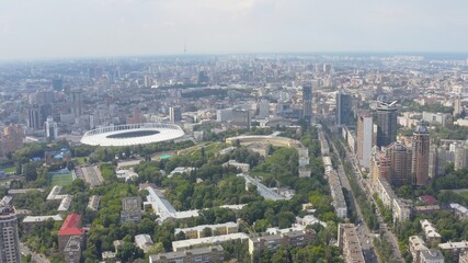 Fototapeta na wymiar Stadium in a green city, a terrible sky and the sun's rays. Kyiv, Ukraine - Cityscape Aerial Flight
