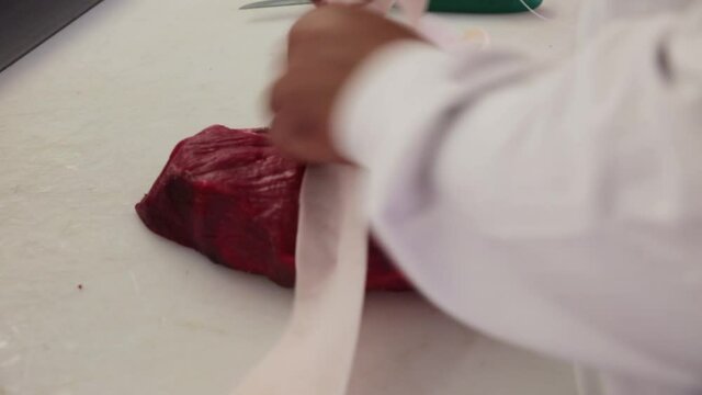 Bardage et le ficelage d'un rosbif coup&eacute; dans l'aiguillette de rumsteak. 