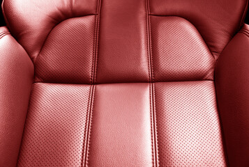 Modern luxury car red leather interior. Part of red leather car seat details with stitching. Interior of prestige car. Comfortable perforated leather seats. Perforated leather.