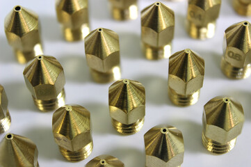 3d printer brass nozzles in a row or array on white background. Additive technology component.