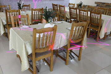 Russian restaurant interior, tables with pine trees and wooden chairs in empty hall