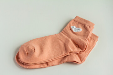 A pair of new women's pink socks with hearts.