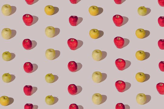 Creative pattern made with fresh appls against  passtel beige background . Minimal fruit layaout.
